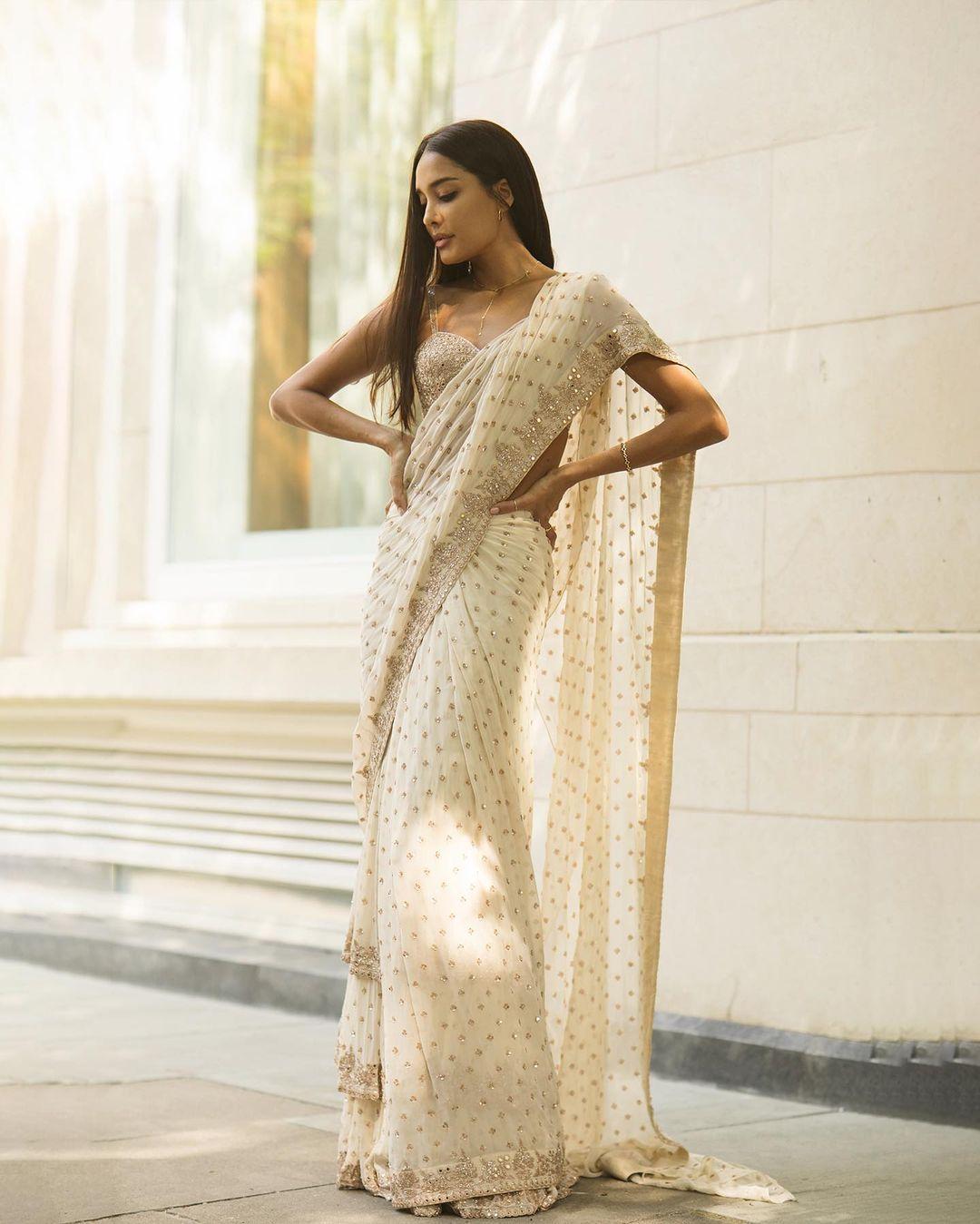 Grace and glamour merge as Lisa Haydon dons a stunning white saree with a sparkling silver blouse.